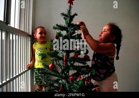 salvador, bahia / brasilien - 24. november 2019: In der Stadt Salvador wird das Kind beim Dekorieren des weihnachtsbaums gesehen. *** Ortsüberschrift *** Stockfoto