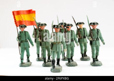 Reamsa Spanish Guardia Civil, Civil Guard Kunststoff-Spielzeugfiguren. Mehrere marschierten mit einem Büro an der Front und schulterten ein Schwert und einen Fahnenträger dahinter. Stockfoto