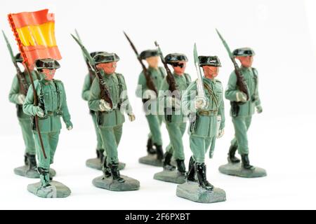 Reamsa Spanish Guardia Civil, Civil Guard Kunststoff-Spielzeugfiguren. Mehrere marschierten mit einem Büro an der Front und schulterten ein Schwert und einen Fahnenträger dahinter. Stockfoto