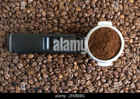 Gemahlener Kaffee in einem Horn zwischen den Bohnen. Konzept für die Zubereitung von Hauskaffee. Horizontale Ausrichtung. Draufsicht. Stockfoto