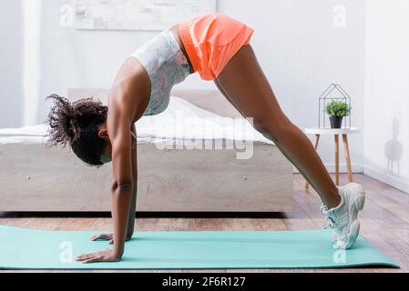 afroamerikanische Frau in Sportbekleidung und Turnschuhen, die auf Fitness trainieren Mat Stockfoto