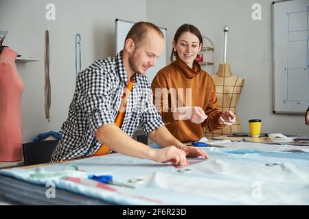 Mann, der Messungen auf Stoff mit Lineal durchführt Stockfoto