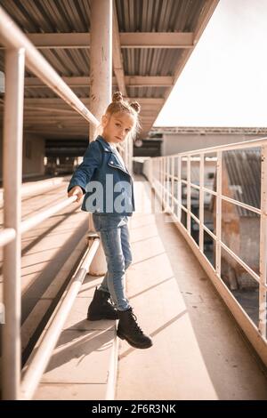 Stilvolle schöne Mädchen von etwa sieben in einer Denim-Jacke Spaziergänge auf der Straße Stockfoto