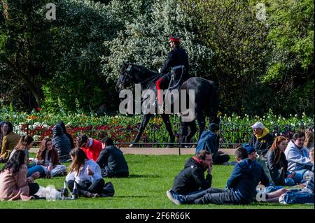 London, Großbritannien. April 2021. Ein Kavallerieoffizier fährt vorbei, während die Menschen das Frühlingswetter im St. James Park genießen, während London aus der Sperre ausbricht 3., London, UK Credit: Guy Bell/Alamy Live News Stockfoto