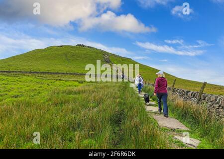 Menschen, die auf dem Fußweg zum Gipfel des Hügels Shutlingsloe, in der Grafschaft von Shenhire, England, Großbritannien, wandern Stockfoto