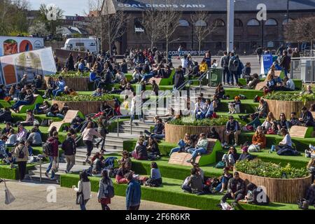 London, Großbritannien. April 2021. Die Menschen genießen die Sonne auf den Stufen am Granary Square in King's Cross, London. Mit Blick auf den Regent's Canal und von Frühjahr bis Winter mit Kunstrasen bedeckt, ziehen die beliebten Stufen wieder einmal Menschenmassen an, da die britischen Sperrbeschränkungen gelockert werden. (Foto: Vuk Valcic/SOPA Images/Sipa USA) Quelle: SIPA USA/Alamy Live News Stockfoto