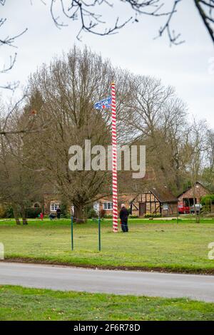Rot und weiß umwickelt Maypole auf dem Grün in Ickwell, Bedfordshire, Großbritannien. Stockfoto