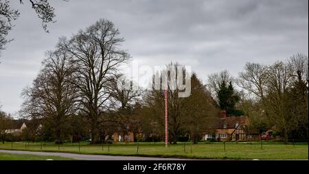 Rot und weiß umwickelt Maypole auf dem Grün in Ickwell, Bedfordshire, Großbritannien. Stockfoto