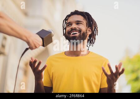 Foto-Porträt eines Mannes mit Dreadlocks lächelnd im Gespräch mit dem Reporter Teilnahme an öffentlichen Fragen im Mikrofon sprechen Stockfoto
