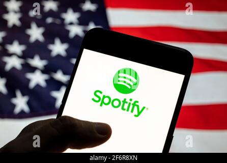 In dieser Abbildung ist das Spotify-Logo der schwedischen Musik-Streaming-Plattform auf einem Android-Mobilgerät mit der Flagge der Vereinigten Staaten von Amerika (USA), die allgemein als die Vereinigten Staaten (USA oder USA) bekannt ist, im Hintergrund zu sehen. Stockfoto