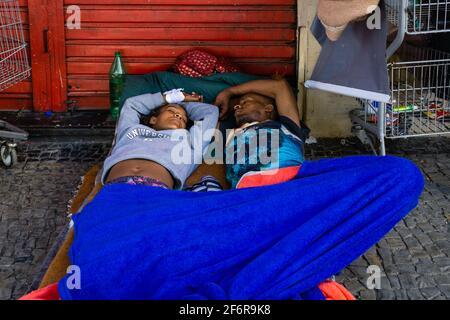 Brasilianisches obdachloses Paar, das auf dem Bürgersteig einer Straße schläft. Stockfoto