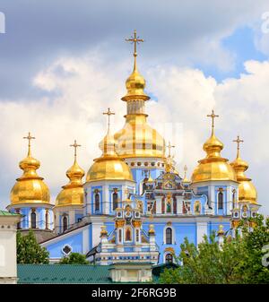 Goldene Kuppeln der St. Michael's Golden-Domed Cathedral in Kiew im Frühling an einem warmen Frühlingstag gegen einen blau bewölkten Himmel. Stockfoto