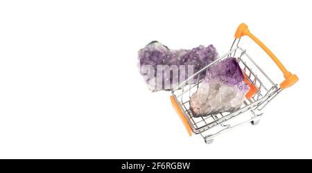 Zwei rohe natürliche purpurrote Amethysten-Kristalle isoliert auf weißem Hintergrund mit Warenkorb. Banner mit Kopierbereich. Stockfoto