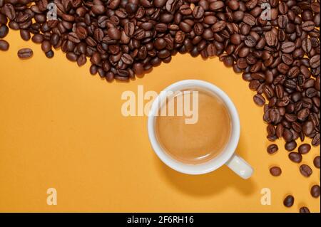 Tasse Kaffee auf gelbem Hintergrund und Toast Kaffeebohnen Stockfoto