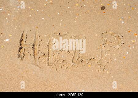 Das Wort Hilfe in den Sand geschrieben in Großbuchstaben. Das Konzept eines Hilferrufs. Hochwertige Fotos Stockfoto