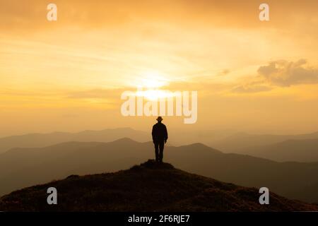 Allein Tourist am Rande der Klippe vor der Kulisse einer unglaublichen Sonnenuntergang Berglandschaft Stockfoto