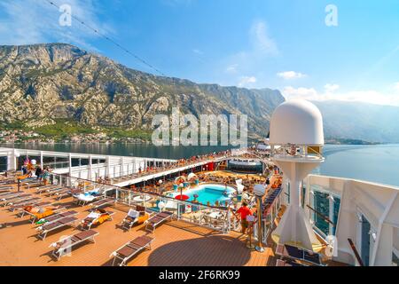 Touristen auf einem großen Schiff in der Boka Bay in der Nähe von Perast, die in Richtung des Kreuzfahrthafens Kotor Montenegro an der Adria fahren. Stockfoto