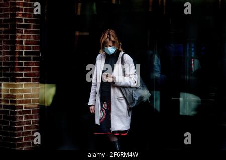 Frau, die ihr Mobiltelefon auf der Straße anschaut. Stockfoto