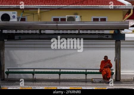 Bangkok, Thailand - 16. Juli 2016: Ein Mönch wartet geduldig auf seinen Bus. Stockfoto