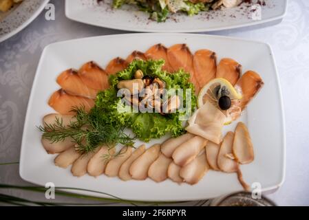 Schneiden verschiedener Fischarten. Schneiden von roten und weißen Fischen. Festlicher Tisch Stockfoto