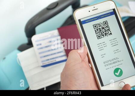 Das digitale grüne Zertifikat der europäischen Union mit dem QR-Code auf dem Bildschirm eines Smartphones, das von einer Hand am Flughafen für die Reise gehalten wird. Impfung Stockfoto