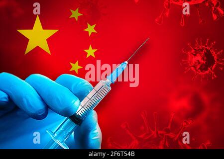 China Covid-19 Impfkampagne. Eine Hand in einem blauen Gummihandschuh hält eine Spritze mit Covid-19-Virus-Impfstoff vor der China-Flagge. Coronavirus vac Stockfoto