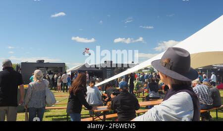 Motocross-Fahrer beim Feldtag 2021 in Feilding, NZ, einen Sprung neben der Menge an Food Court Stockfoto