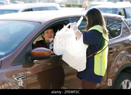 Brentwood, Usa. April 2021. Ein Freiwilliger liefert einem Kunden am Karfreitag in der St. Mary Magdalen School in Brentwood, Missouri, am Freitag, dem 2. April 2021, einen Auftrag zum Abendessen in seinem Auto. Aufgrund der COVID-19-Beschränkungen kann die Kirche das beliebte fastenessen nur mit dem Auto servieren. Die Organisatoren sagen, dass über 500 Autos durchfahren werden und 2000 Fischstücke serviert werden. Foto von Bill Greenblatt/UPI Credit: UPI/Alamy Live News Stockfoto