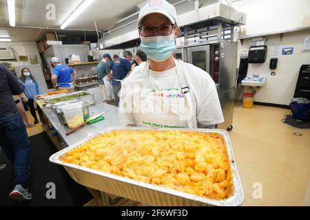 Brentwood, Usa. April 2021. Der Freiwillige Molly Hodge trägt ein Tablett mit mac und Käse, das verpackt und am Freitag, den 2. April 2021, einem wartenden Kunden in seinem Auto an der St. Mary Magdalen School in Brentwood, Missouri, geliefert wird. Aufgrund der COVID-19-Beschränkungen kann die Kirche das beliebte fastenessen nur mit dem Auto servieren. Die Organisatoren sagen, dass über 500 Autos durchfahren werden und mehr als 2000 Fischstücke serviert werden. Foto von Bill Greenblatt/UPI Credit: UPI/Alamy Live News Stockfoto