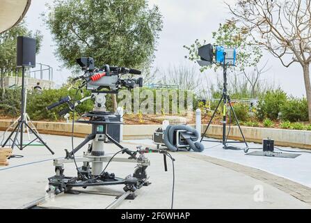 Tel Aviv - Israel, 11. März 2021: Professionelle Ausrüstung für das Filmen von TV-Shows und Filmen. Videokamera auf Stativ mit Schienen und Beleuchtungseinrichtung. Stockfoto