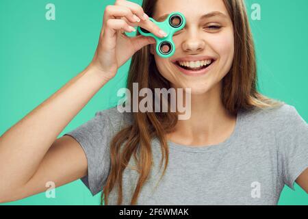 Fröhliche Frau mit einem Spinner in der Hand Grüner Hintergrund Stockfoto