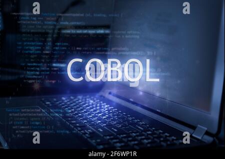 COBOL-Beschriftung vor Laptop und Code-Hintergrund. Technologiekonzept. Stockfoto