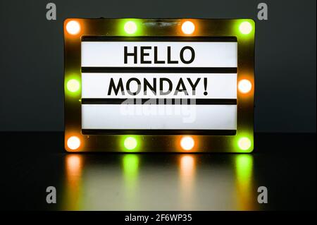 Leuchtkasten mit gelben und orangen Lichtern im dunklen Raum mit Worten - Hallo Montag! Stockfoto