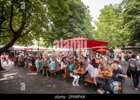 München, Deutschland - im Freiluftbiergarten am Viktualienmarkt, auf dem Gourmetmarkt und bei touristischen Attraktionen haben die Menschen Freizeit, bayerisches Essen und Bier Stockfoto