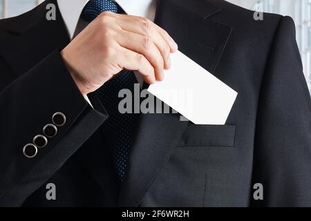Geschäftsmann nimmt eine leere Visitenkarte aus seiner Tasche. Stockfoto