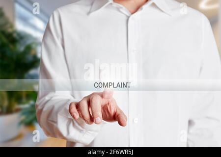 Geschäftsmann drückt Beschwerde-Taste auf einem virtuellen Bildschirm. Kundenbeanstandungskonzept. Stockfoto