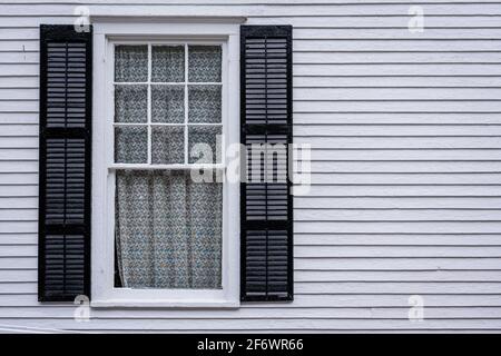 Fenster mit offenen Fensterläden eines weißen Holzhauses Stockfoto