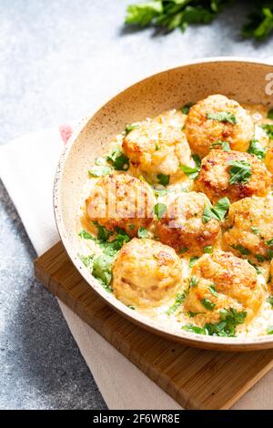 Fleischbällchen in weißer Soße in einer Pfanne auf grauem Hintergrund, bequeme hausgemachte gesunde Lebensmittel Stockfoto