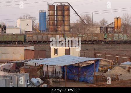 Industriegelände, Fässer, Rohre, Güterwagen. Stockfoto