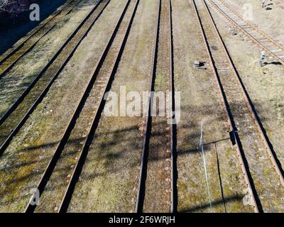 Drohne schoss bei Sonnenuntergang über einer Bahnsortierstation mit Zügen. Foto Bahngleise, Luftaufnahme von oben. Stockfoto