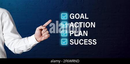 Businessman Hand zeigt mit Häkchen auf die Wörter Ziel, Plan, Aktion und Erfolg. Erfolgsschritte im Geschäftsstrategiekonzept. Stockfoto