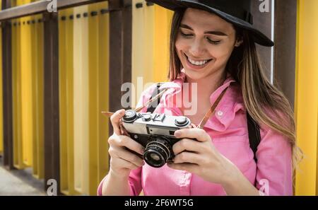 Junge Reisefrau, die im Urlaub mit einer alten Vintage-Kamera fotografiert Stockfoto