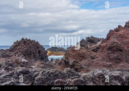 Natürliches vulkanisches Gestein in der Nähe von Ponta da Ferraria, dem Ort, an dem sich heiße Quellen mit Meerwasser vermischen, auf der Insel Sao Miguel, Azoren, Portugal Stockfoto