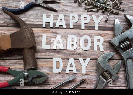 Happy Labor Day Text mit vielen praktischen Werkzeugen auf Holzhintergrund Stockfoto