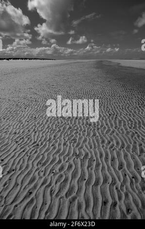 Welliger Sand am Strand in der Nähe von Brancaster / RSPB Titchwell Marsh, Norfolk, Großbritannien. S/W Stockfoto