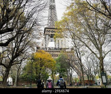 Paris, 18. November 2019: Männliche und weibliche Touristen schauten auf den berühmten Eiffelturm von Paris, Frankreich Stockfoto