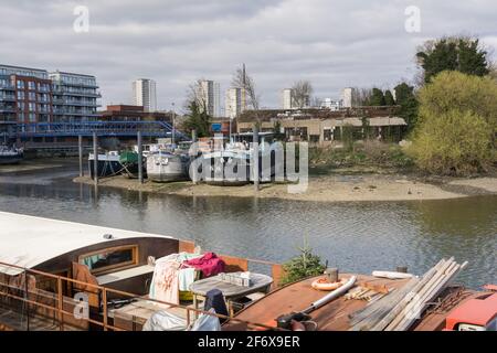 John’s Boat Works Ltd – farbenfrohe Hausboote werden auf Lot's Ait an der Themse gegenüber dem Waterman's Arts Centre, Brentford, London, Großbritannien, repariert Stockfoto