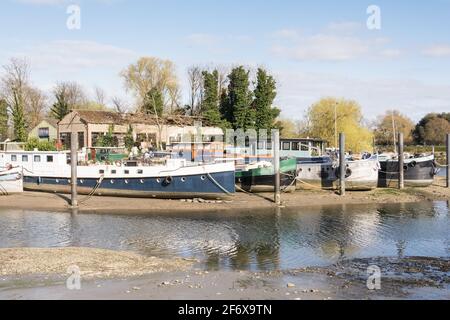 John’s Boat Works Ltd – farbenfrohe Hausboote werden auf Lot's Ait an der Themse gegenüber dem Waterman's Arts Centre, Brentford, London, Großbritannien, repariert Stockfoto