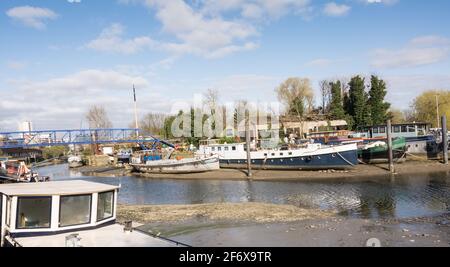 John’s Boat Works Ltd – farbenfrohe Hausboote werden auf Lot's Ait an der Themse gegenüber dem Waterman's Arts Centre, Brentford, London, Großbritannien, repariert Stockfoto