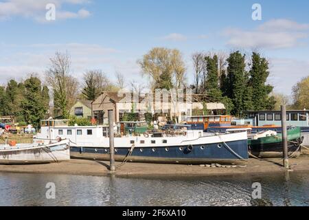 John’s Boat Works Ltd – farbenfrohe Hausboote werden auf Lot's Ait an der Themse gegenüber dem Waterman's Arts Centre, Brentford, London, Großbritannien, repariert Stockfoto